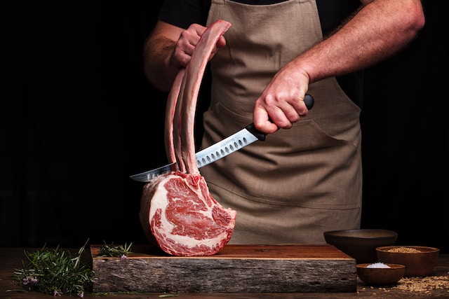 chef cutting tomahawk steak